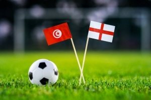 Det engelske og tunesiske flag på en græsplane med en fodbold