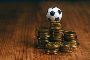 Stabel af mønter med fodbold på toppen