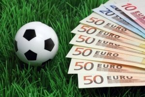 Eurosedler på græsplæne med fodbold