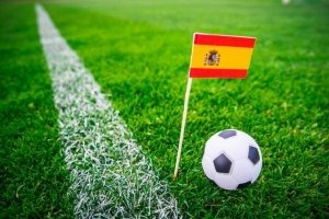Spaniens flag på græsplæne med fodbold foran