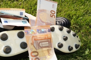 Fodboldstøvler på græsplæne med eurosedler